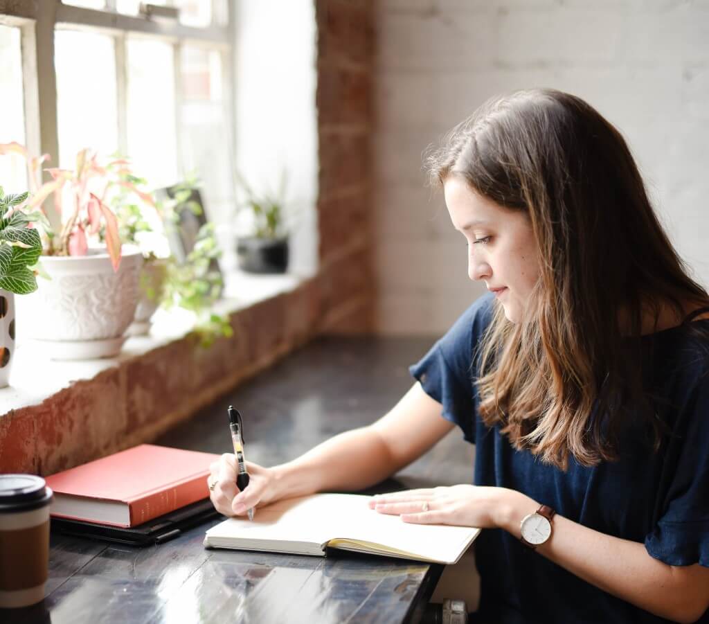 Young graduate Hannah Olinger writing thesis at home photo