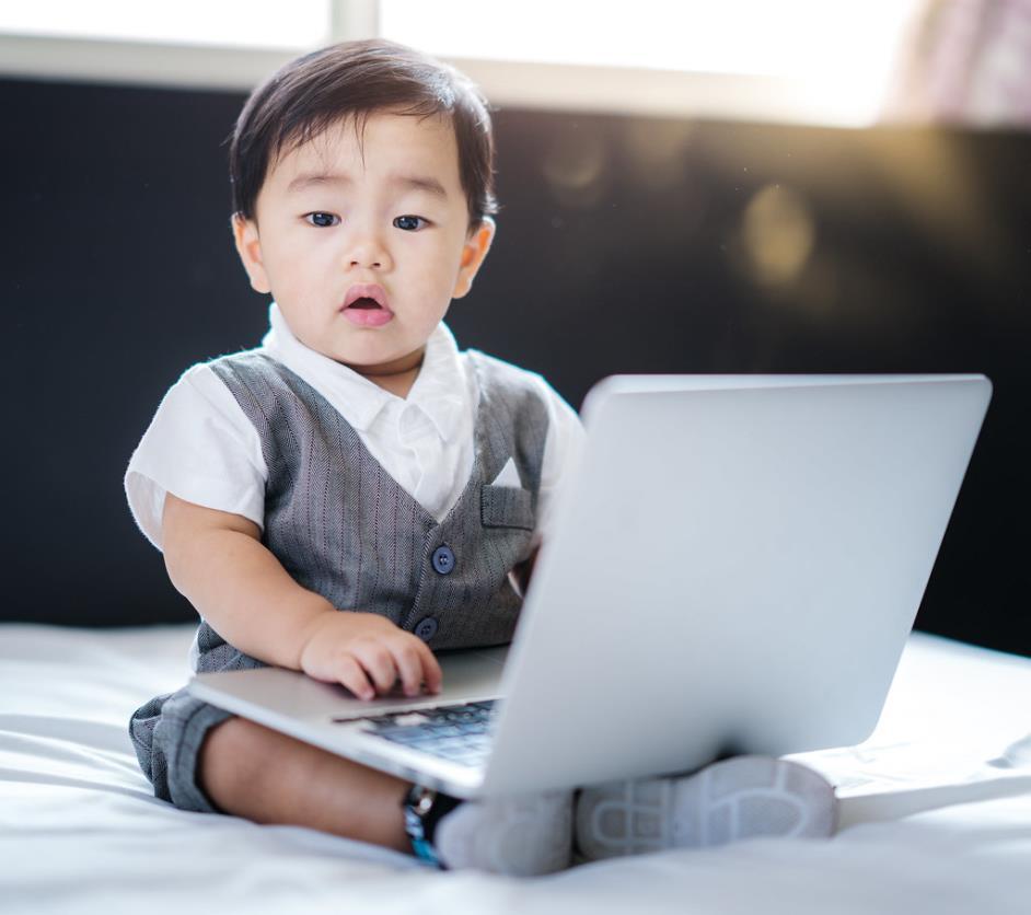 Asian tech-savvy baby in business concept use computer laptop. Talented cute baby boy, technology, notebook.