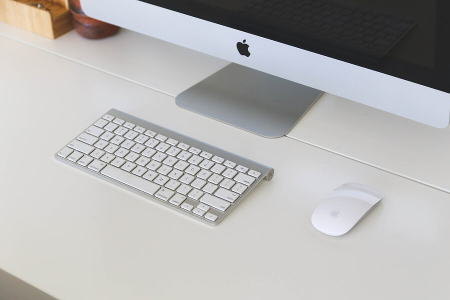 Apple Mac Computer, Keyboard on Desk. MacOS Catalina - Apple Desktop Operating System. Software by Apple.