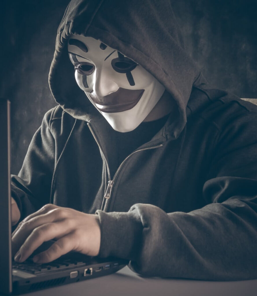 Anonymous computer hacker in white mask and hoodie.
