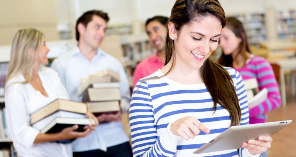 Woman with Ebook Reader While Friends Carry Books.