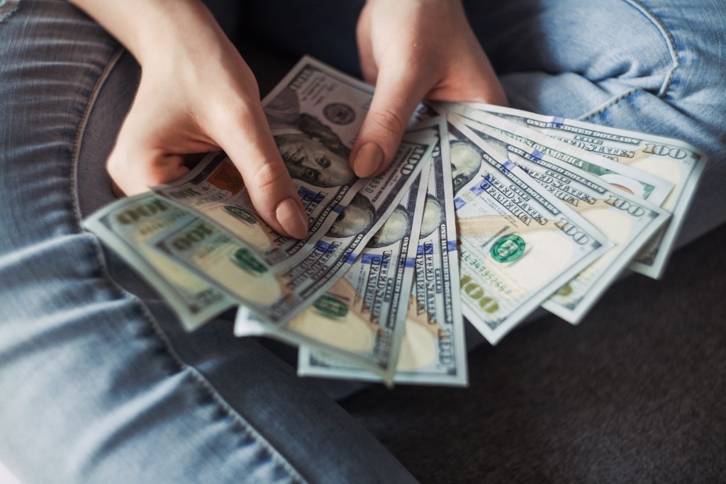 Girl holding American dollar bills. Financial freedom.