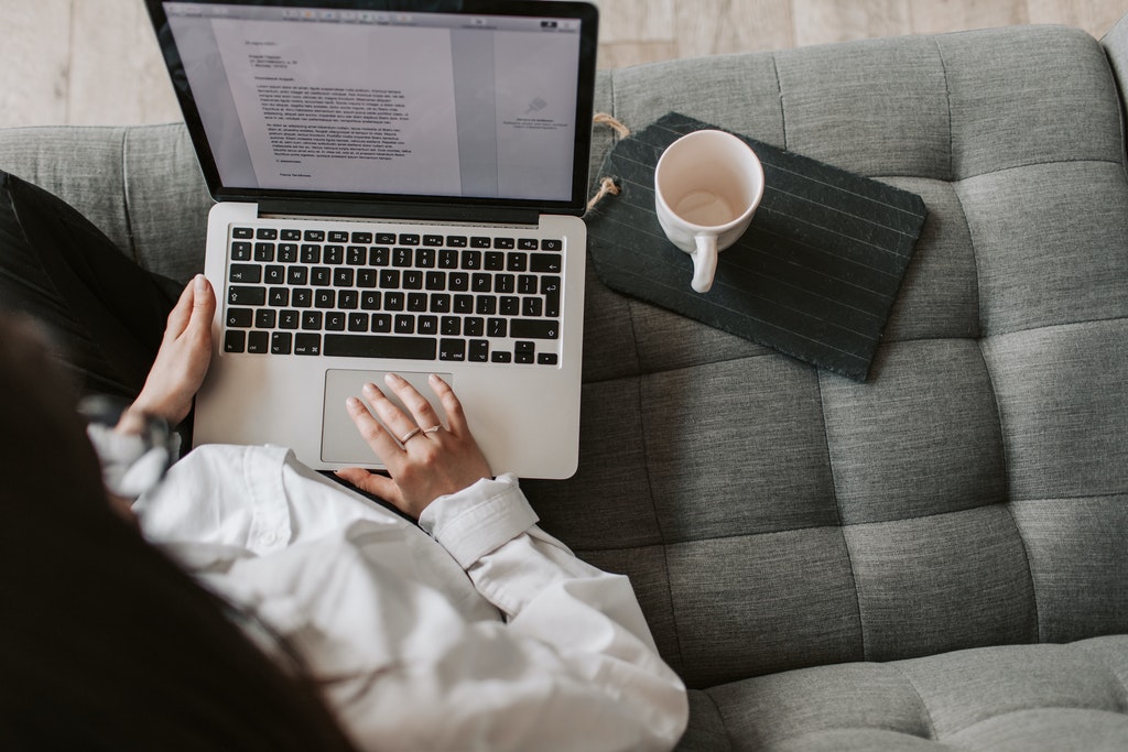Woman Technical Writer Using Laptop on Sofa at Home