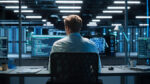 Professional IT Programmer Working in Data Center on Desktop Computer with Two Displays, Doing Development of Software and Hardware. Displays Show Blockchain. Data Network Architecture.