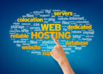 Hand Pointing at a Web Hosting Word Cloud on Blue Background