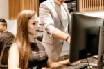 Man Teaching Woman in Front of Monitor