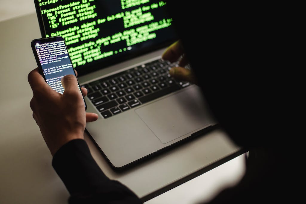 Developer using laptop and smartphone, Mobile app development.