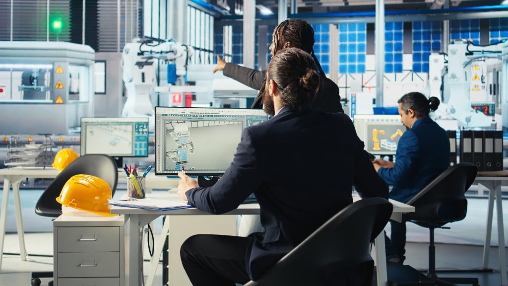 Eco friendly photovoltaics factory manager working with solar engineering team, improving systems reliability. Sustainable energy solar panel manufacturing plant expert providing feedback to workers.