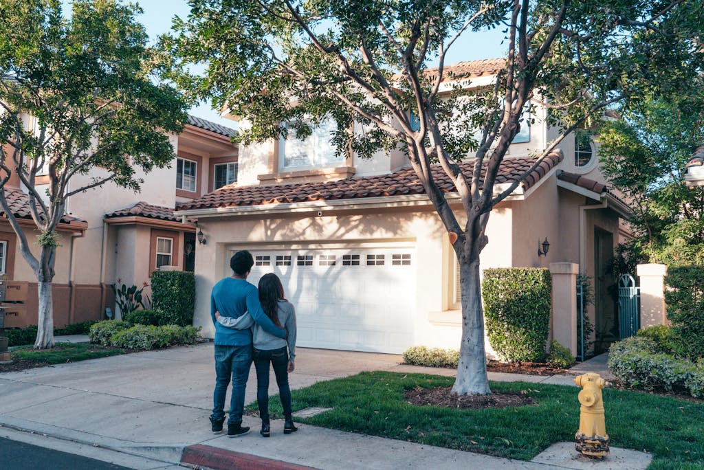 Couple standing in front of their real estate house